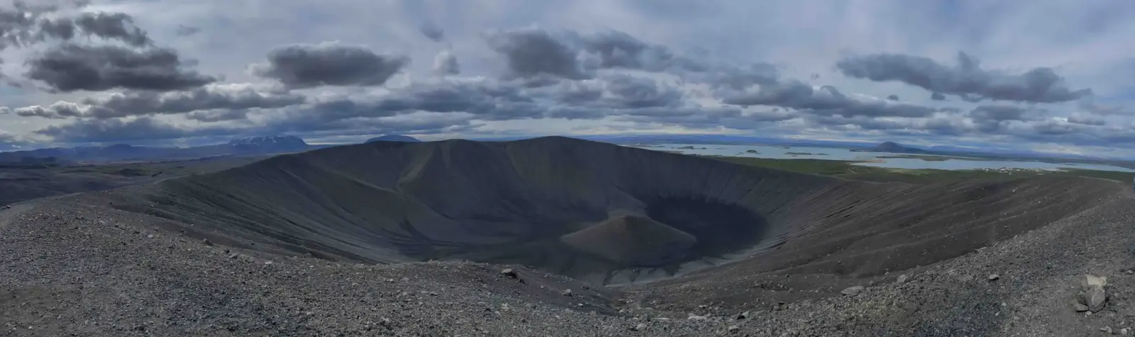 開闊火山地形全景與動態雲層天空，地平線開闊